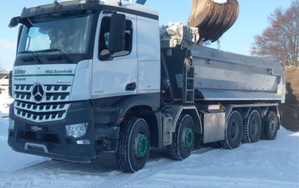 Weisser LKW mit Baggerschaufel